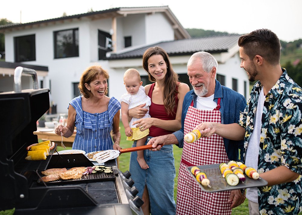 Multigenerational family barbecuing in the backyard.