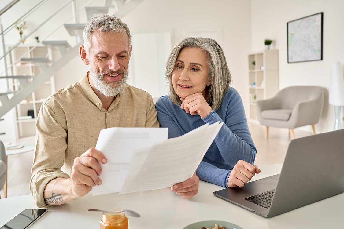 Mature couple looking through financial statements from their financial advisor.