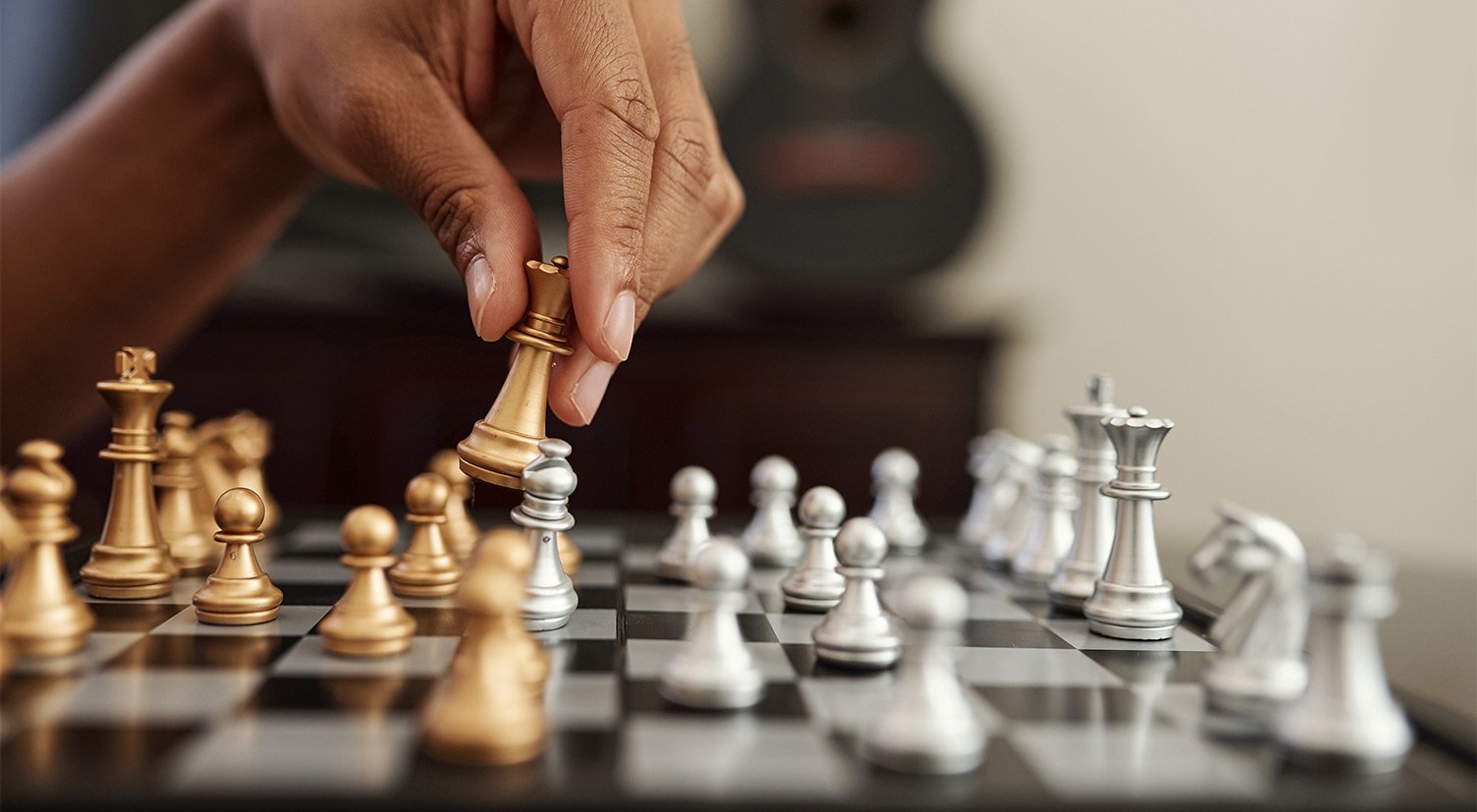 Closeup of a hand holding a chess piece.