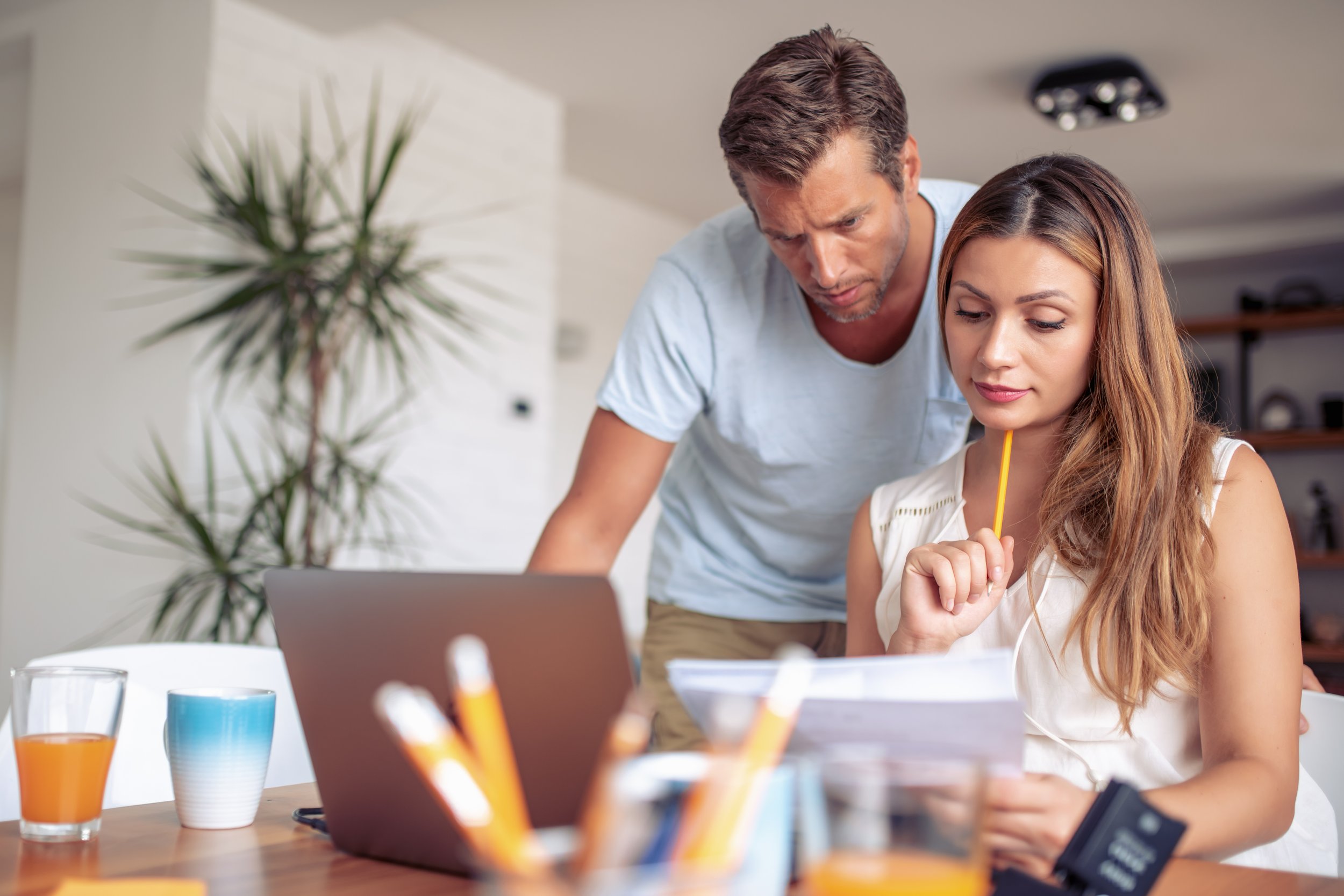 Husband and wife looking at their bills in their home.