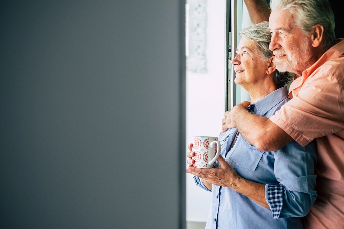 Senior couple looking out an open door.