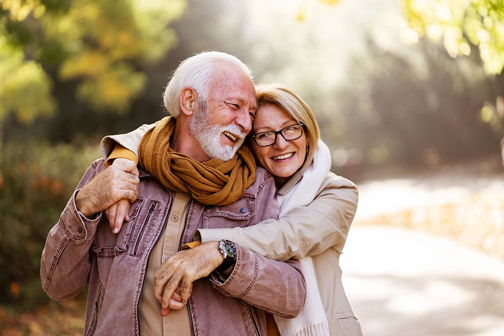 Happy mature couple embracing each other outdoors.