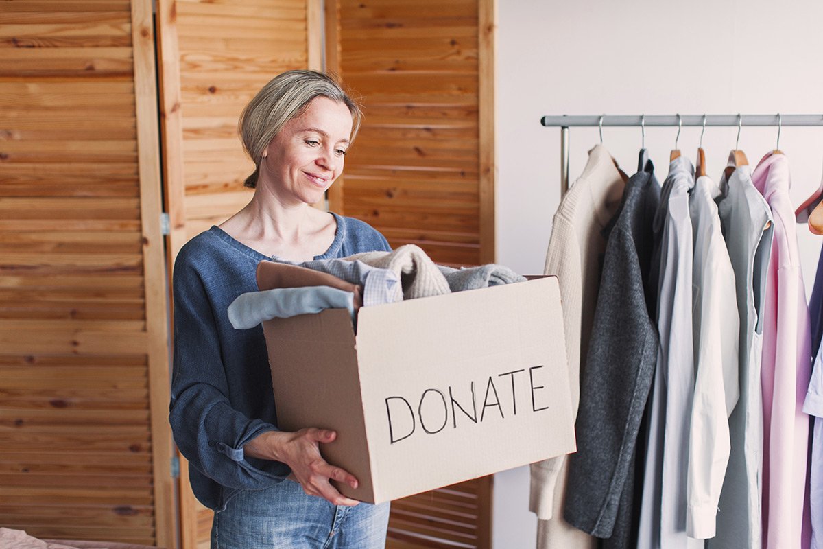 Woman with a box of clothes to donate.