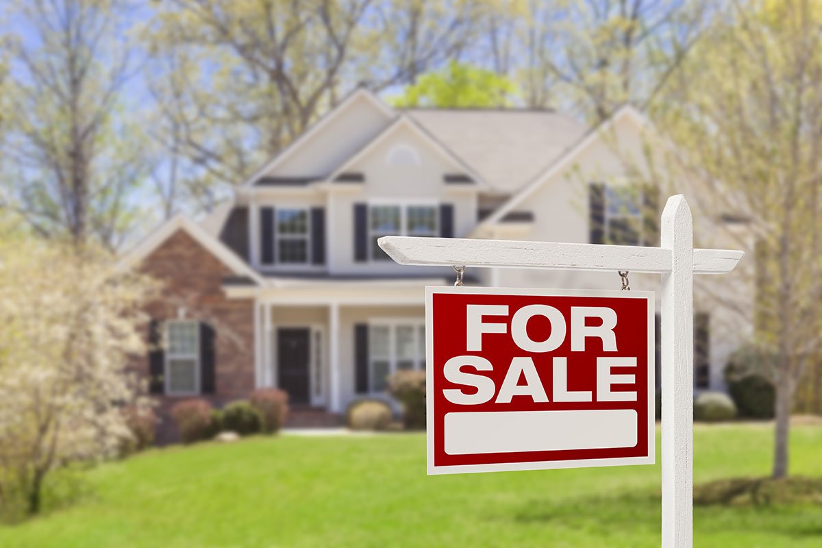 For sale sign in front of house.