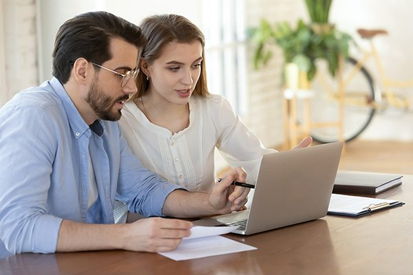 Couple using a laptop to look over their financial plan.