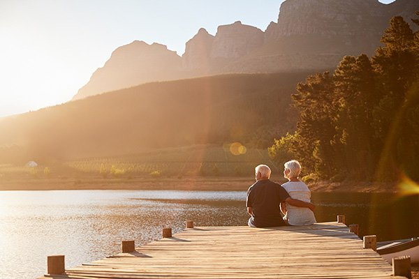 Couple sitting on a dock enjoying retirement.