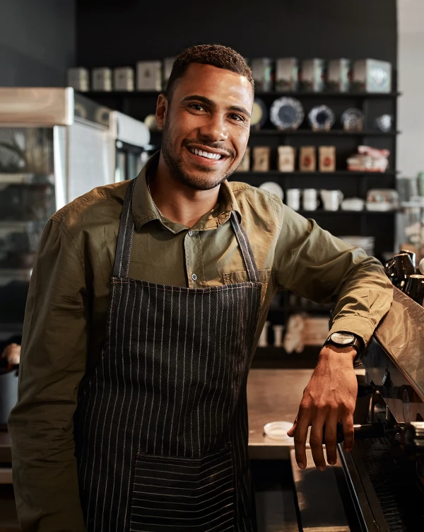 African American business owner posing wearing an apron.