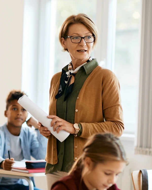 A pre-retiree teacher teaching children in her classroom.