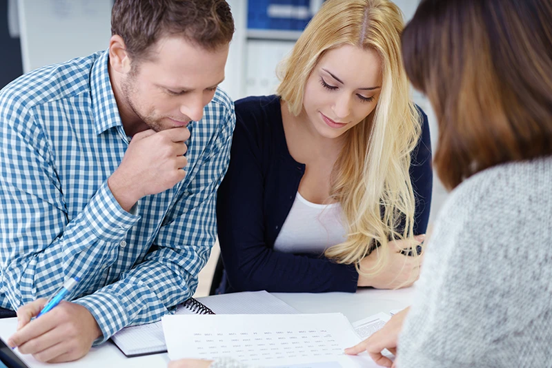 Young couple discussing financial plan with their financial advisor.