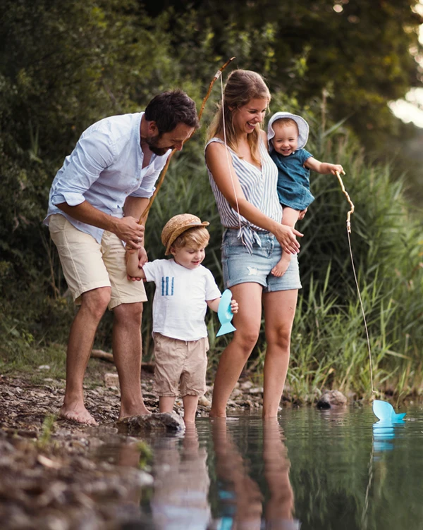 A young family of four at the edge of a creek.