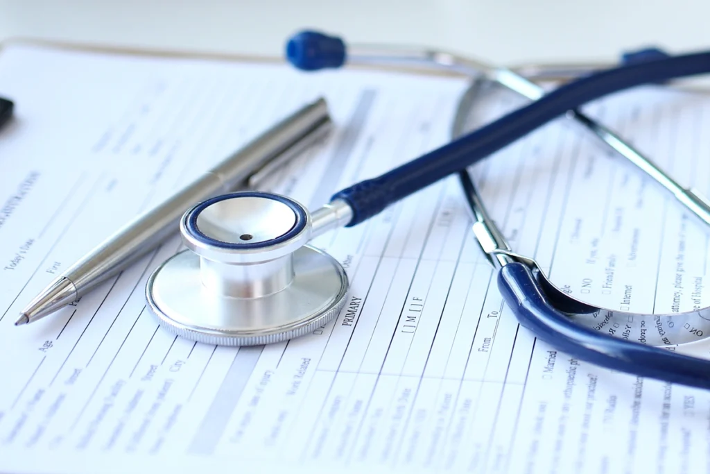 Stethoscope and pen on medical forms.
