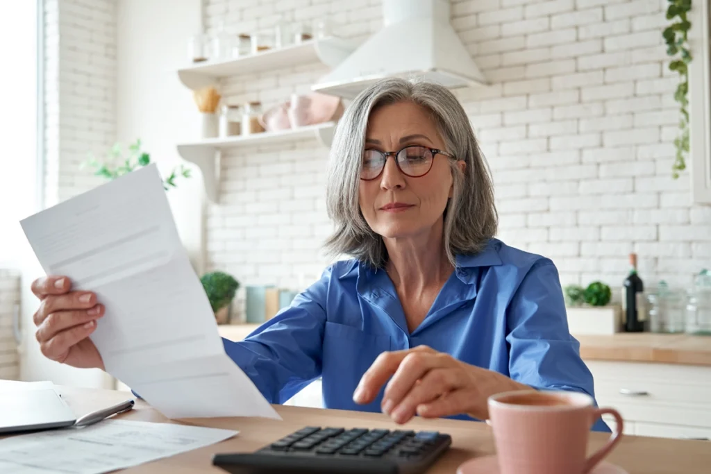 Mature woman looking over financial statements.