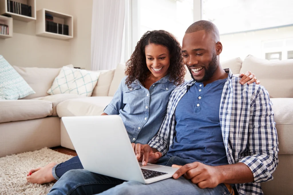 A young couple reviewing their finances on a laptop.