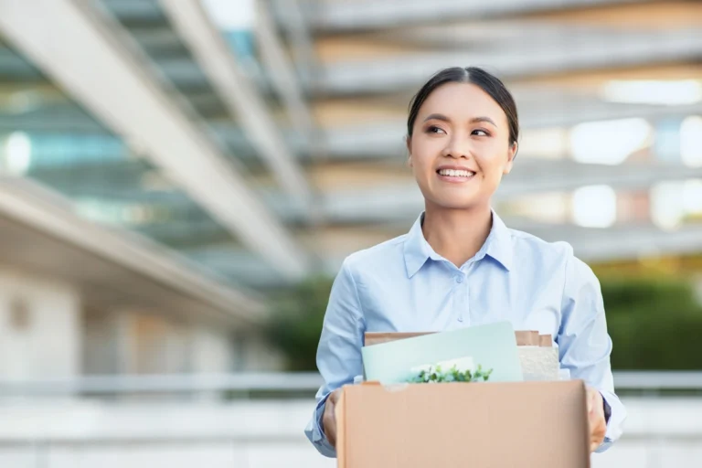 Young businesswoman holding box of belongings as she changes jobs.