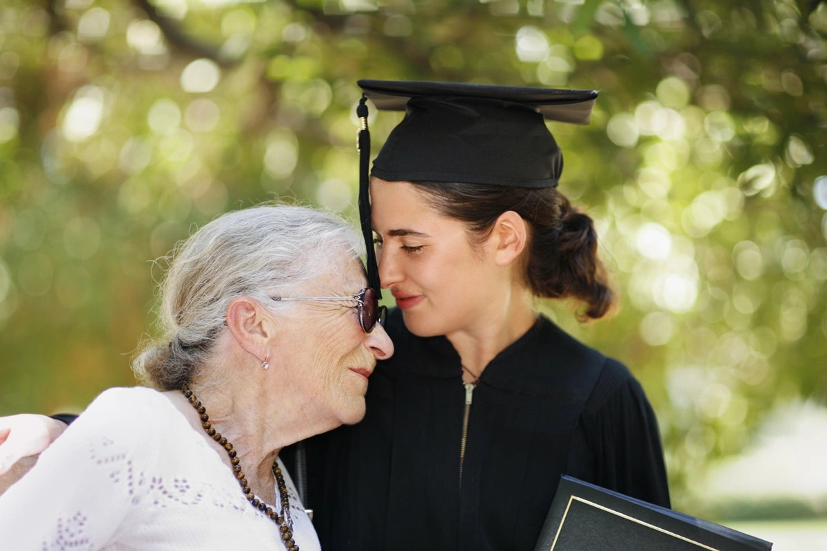 Graduate with her grandma, outdoors.
