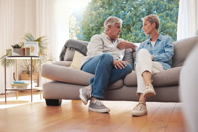 Retired couple sitting on couch discussing their estate plan.