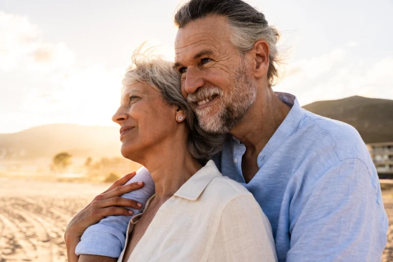 Retired couple embracing outdoors.