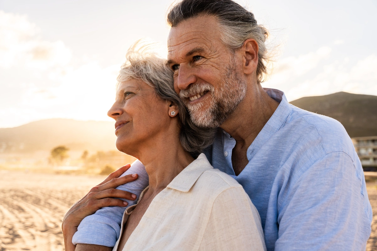 Retired couple embracing outdoors.