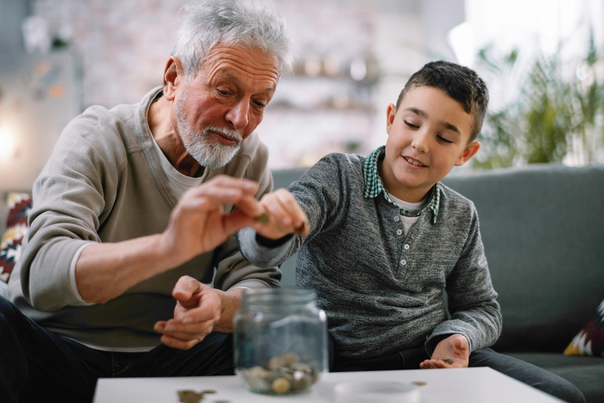 Grandfather teaching grandson about saving money.